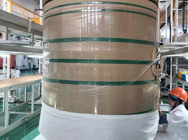 Фотография мастерской, демонстрирующая интегрированную систему защиты Juhong Packing для гигантских рулонов промышленной бумаги. Этот процесс сочетает в себе высокоэффективную стрейч-пленку из ЛПЭНП для влагонепроницаемого и грязеотталкивающего уплотнения с сертифицированной AAR (ID: 124) лентой PET для обеспечения прочной структурной целостности. Являясь разработчиком национального стандарта на обвязку пломб (GB/T 39040–2020), компания Juhong обеспечивает логистику с нулевыми потерями для крупнейших в мире бумажных фабрик во время морских и железнодорожных перевозок.